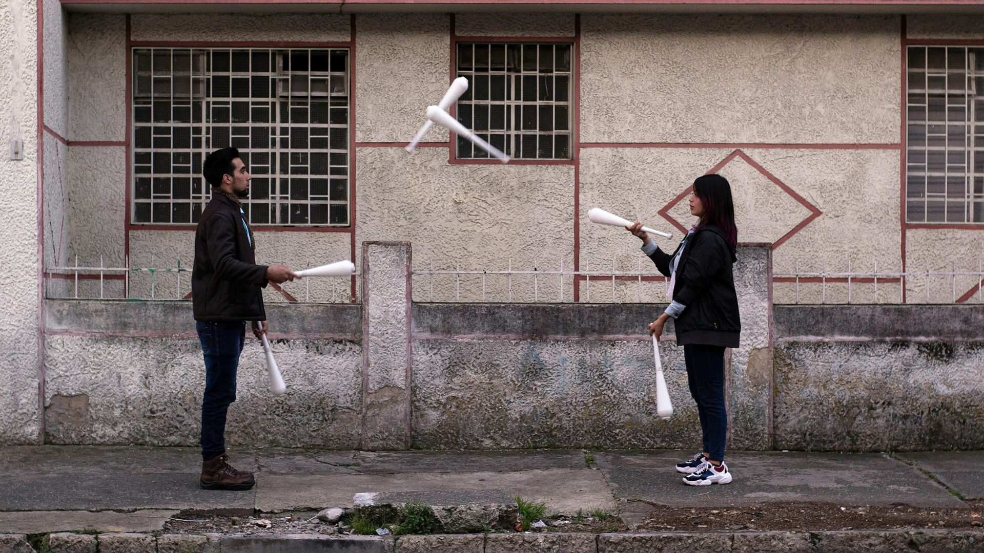 two people juggle batons together